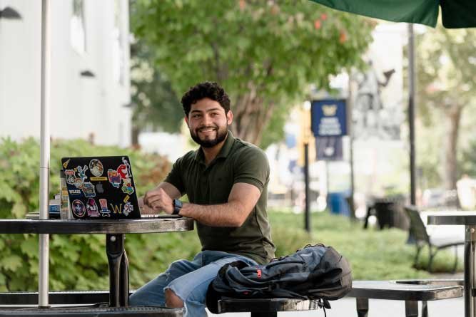 young man with laptop outdoors